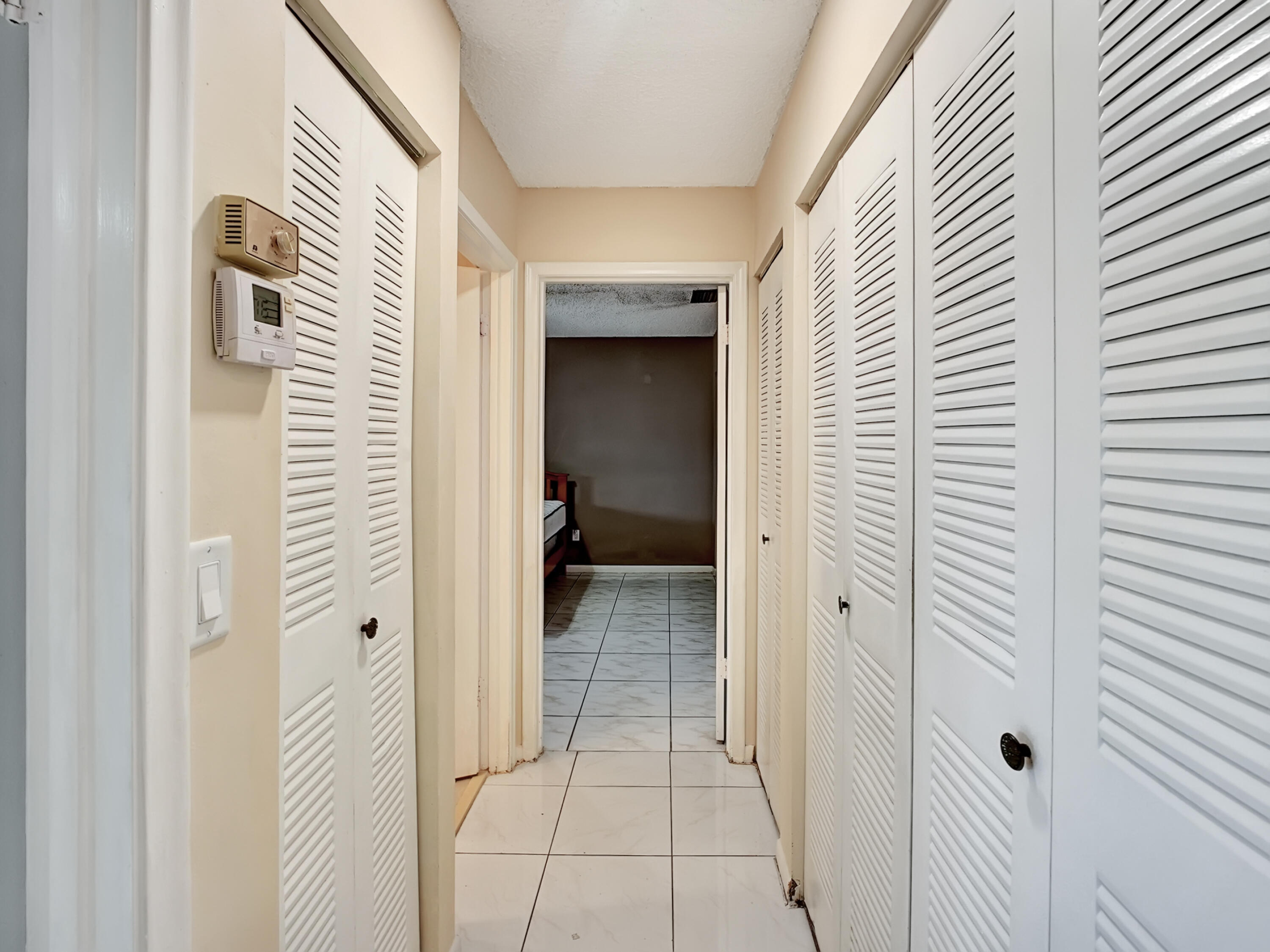1165 Summit Trail Circle, Unit A West Palm Beach, FL 33415 - Photo 16 of 37 a view of a hallway with a white door and a bathroom