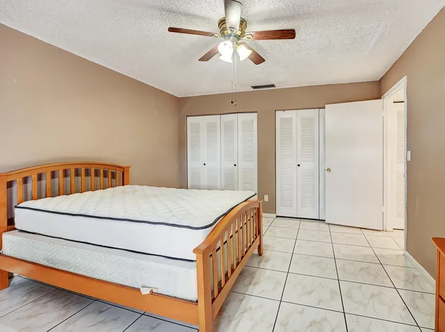 a spacious bedroom with a bed and a chandelier