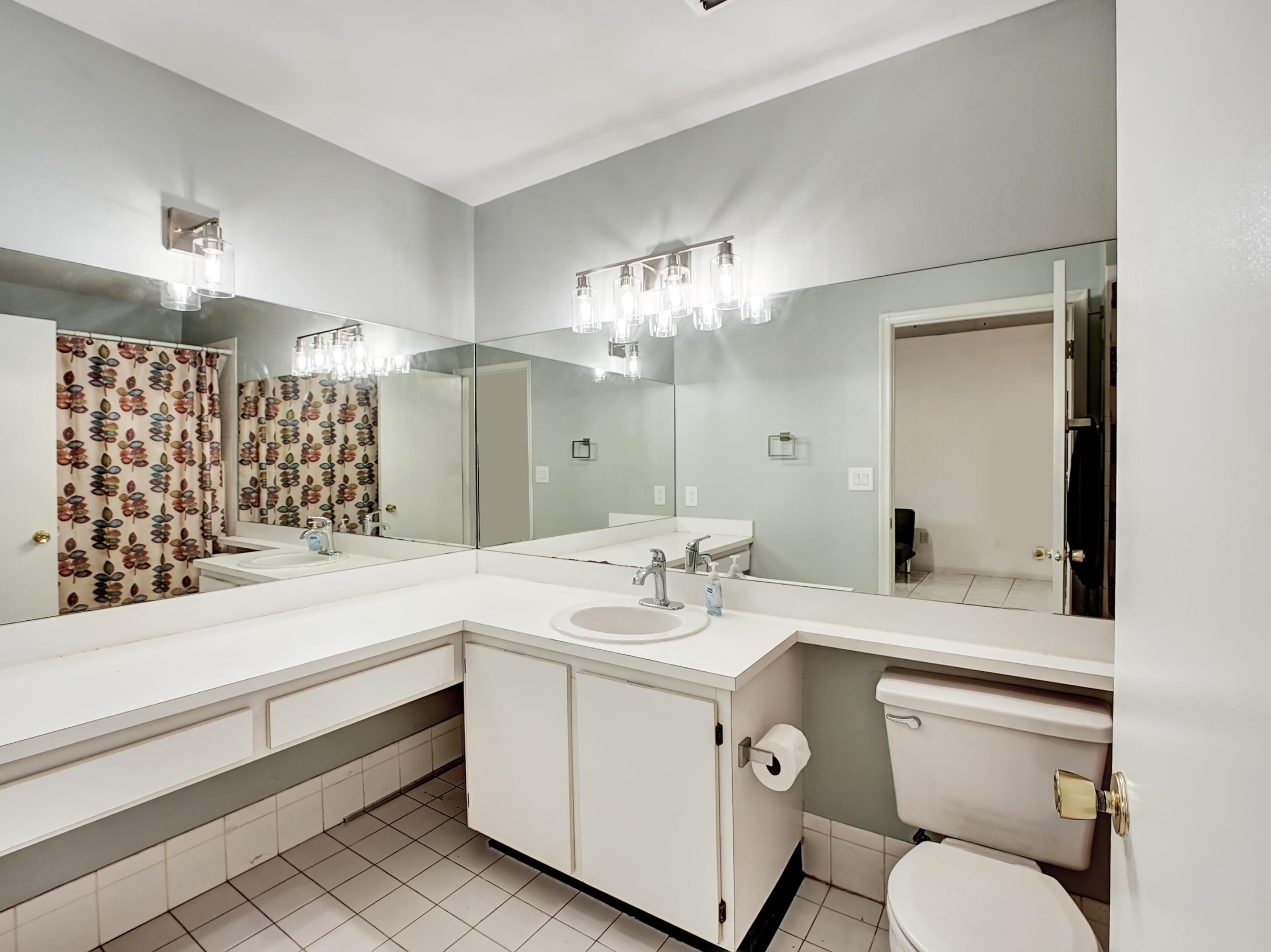 1165 Summit Trail Circle, Unit A West Palm Beach, FL 33415 - Photo 8 of 37 a bathroom with a sink a toilet and a large mirror