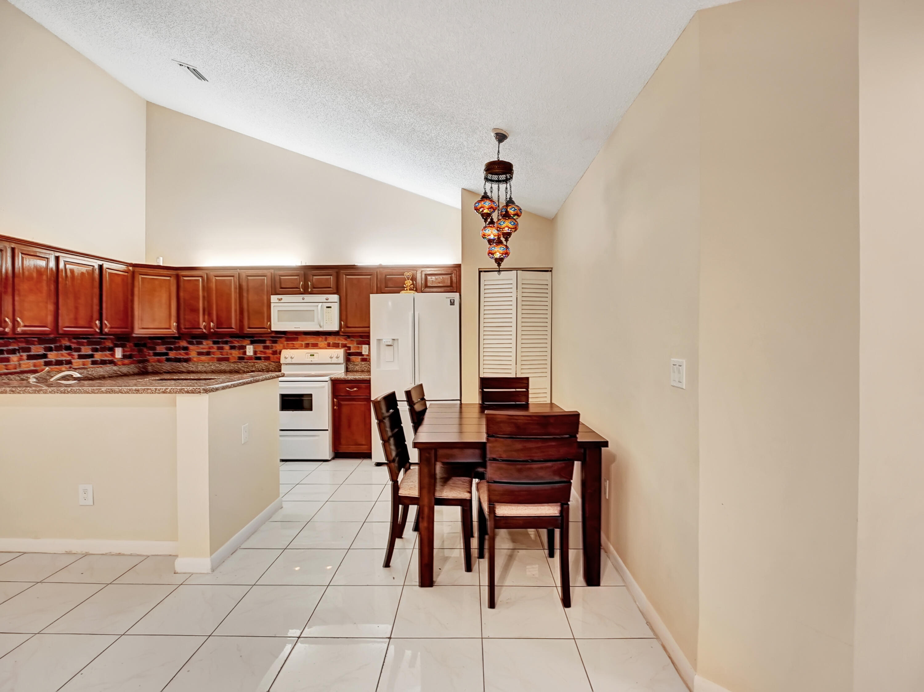1165 Summit Trail Circle, Unit A West Palm Beach, FL 33415 - Photo 10 of 37 a dining room with furniture and a kitchen view