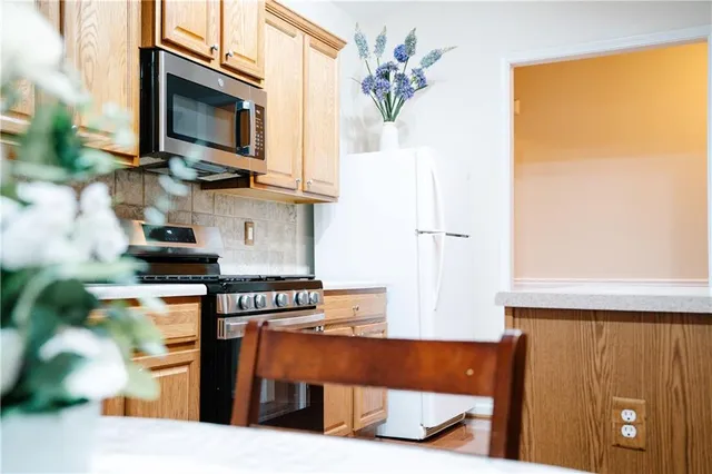 a kitchen with stainless steel appliances granite countertop a stove top oven a sink and a microwave