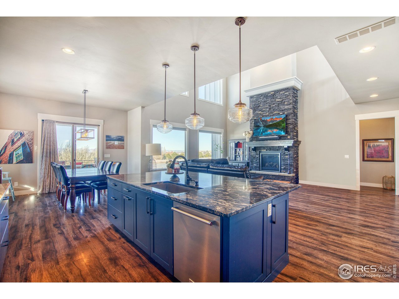 3941 Roper Trail Severance, CO 80524 - Photo 5 of 32 a kitchen with stainless steel appliances granite countertop wooden floors wooden cabinets a sink and a island