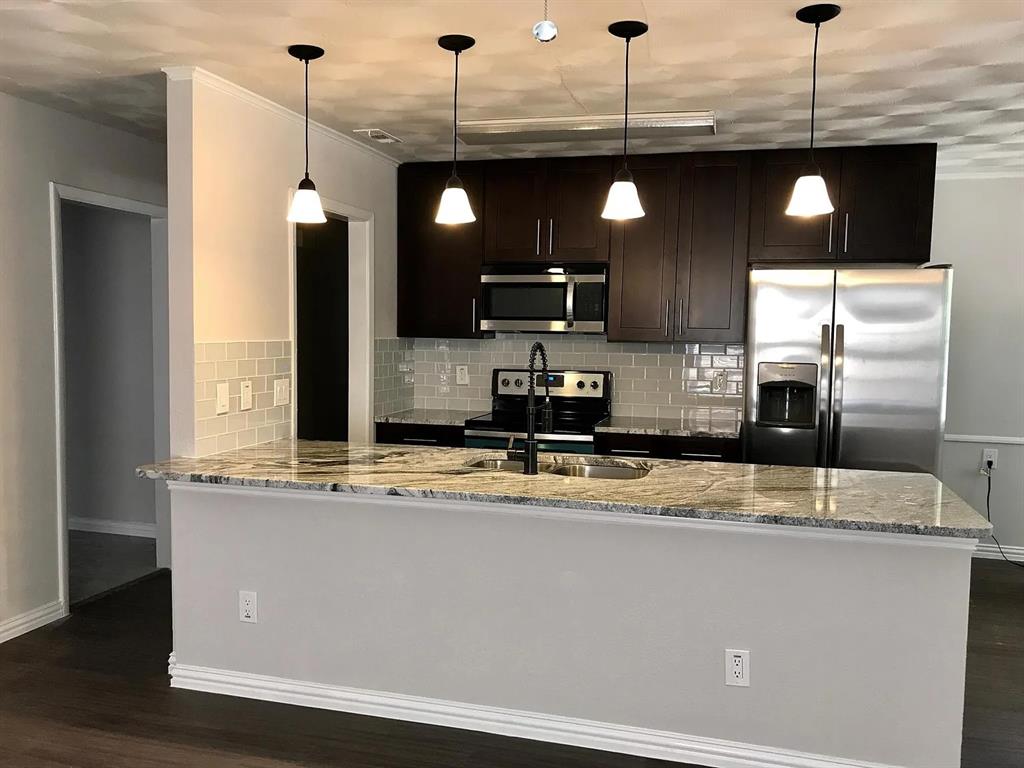 1617 East Union Bower Road Irving, TX 75061 - Photo 3 of 14 a kitchen with stainless steel appliances granite countertop a sink a stove and a wooden floor