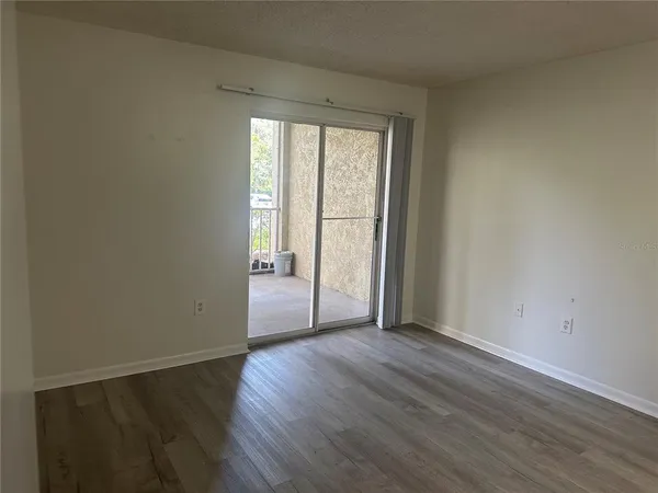 a view of a room with wooden floor and a window