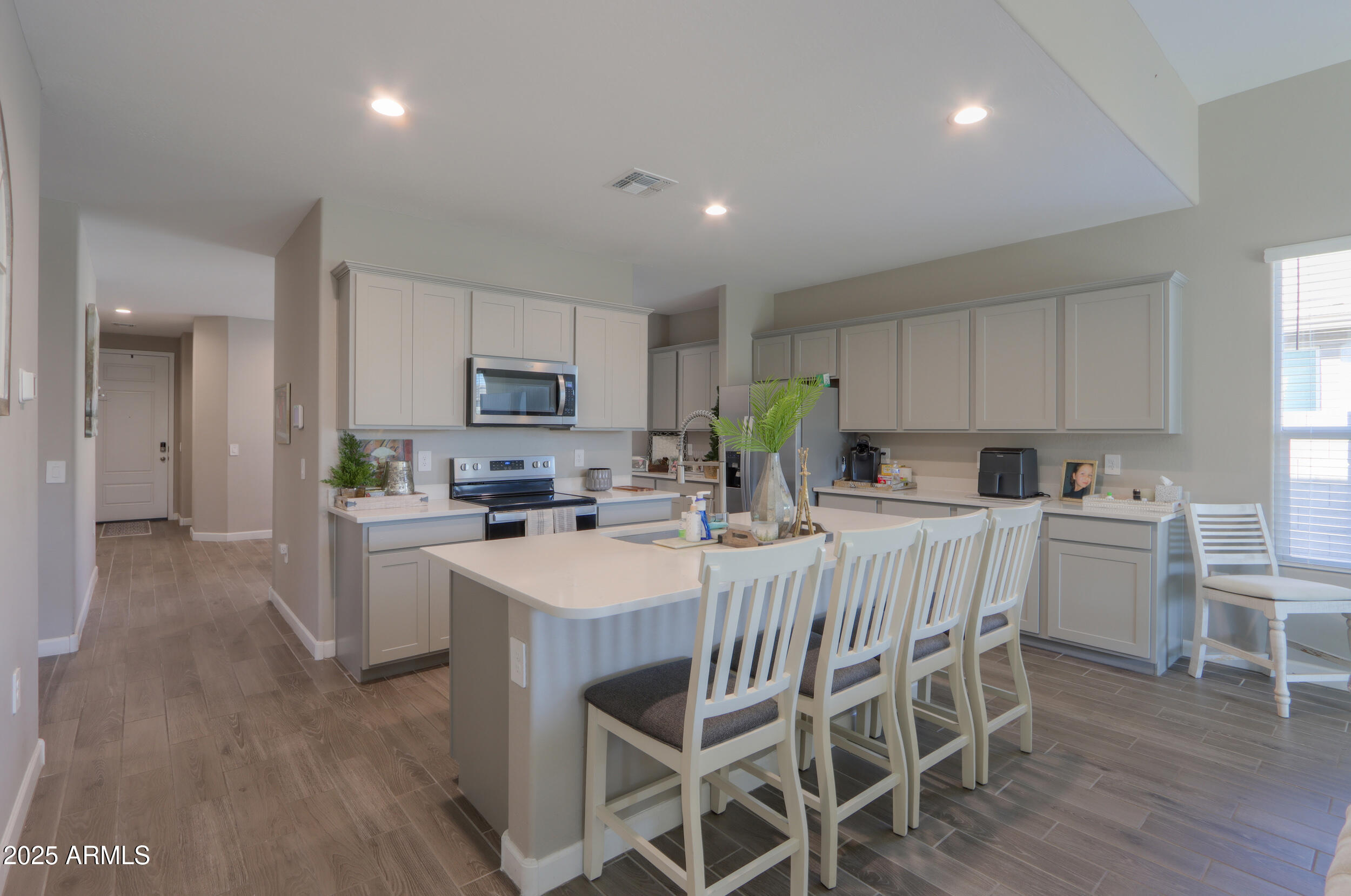 44583 West Palo Olmo Road Maricopa, AZ 85138 - Photo 15 of 43 a kitchen with stainless steel appliances granite countertop a table chairs sink refrigerator and microwave