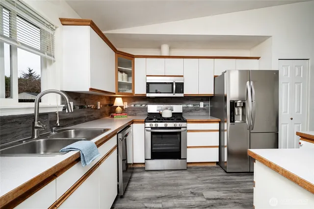a kitchen with stainless steel appliances granite countertop a sink stove and refrigerator