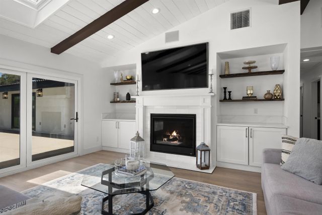 a dining room with furniture wooden floor a flat screen tv and a fireplace