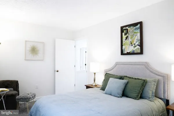 a bedroom with a bed and a painting on the wall