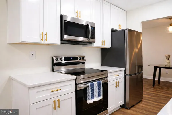 a kitchen with stainless steel appliances a stove microwave and refrigerator