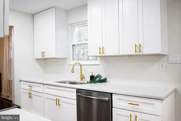 a kitchen with stainless steel appliances white cabinets and a window