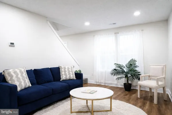 a living room with furniture potted plant and a wooden floor