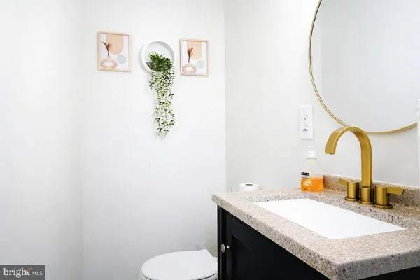 a bathroom with a sink vanity mirror and toilet