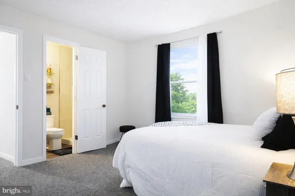 a large bedroom with a bed and wooden floor