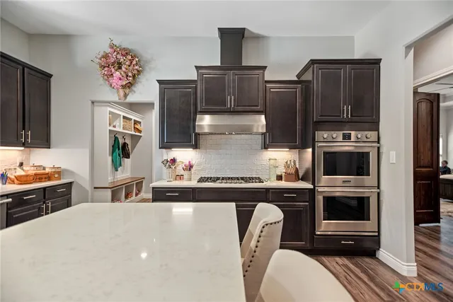 a kitchen with stainless steel appliances a stove refrigerator sink and microwave