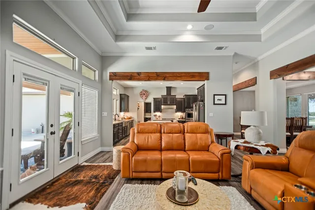 a living room with furniture a flat screen tv and a floor to ceiling window