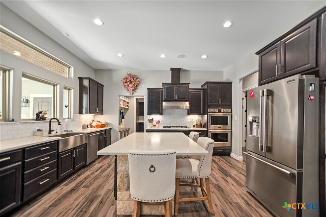 437 Bischoff Road Inez, TX 77968 - Photo 9 of 47 a kitchen with stainless steel appliances granite countertop a refrigerator a sink dishwasher a stove and white cabinets with wooden floor