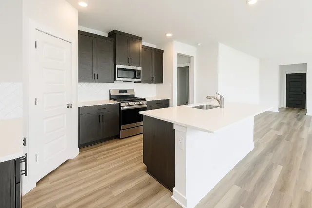 a view of kitchen with sink microwave and refrigerator