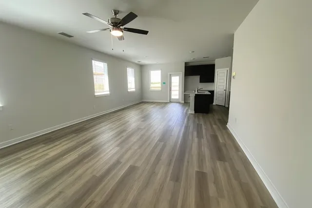 a kitchen with stainless steel appliances a sink a stove top oven a refrigerator with wooden floor