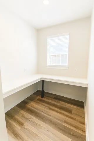 a view of a workspace with furniture and a window