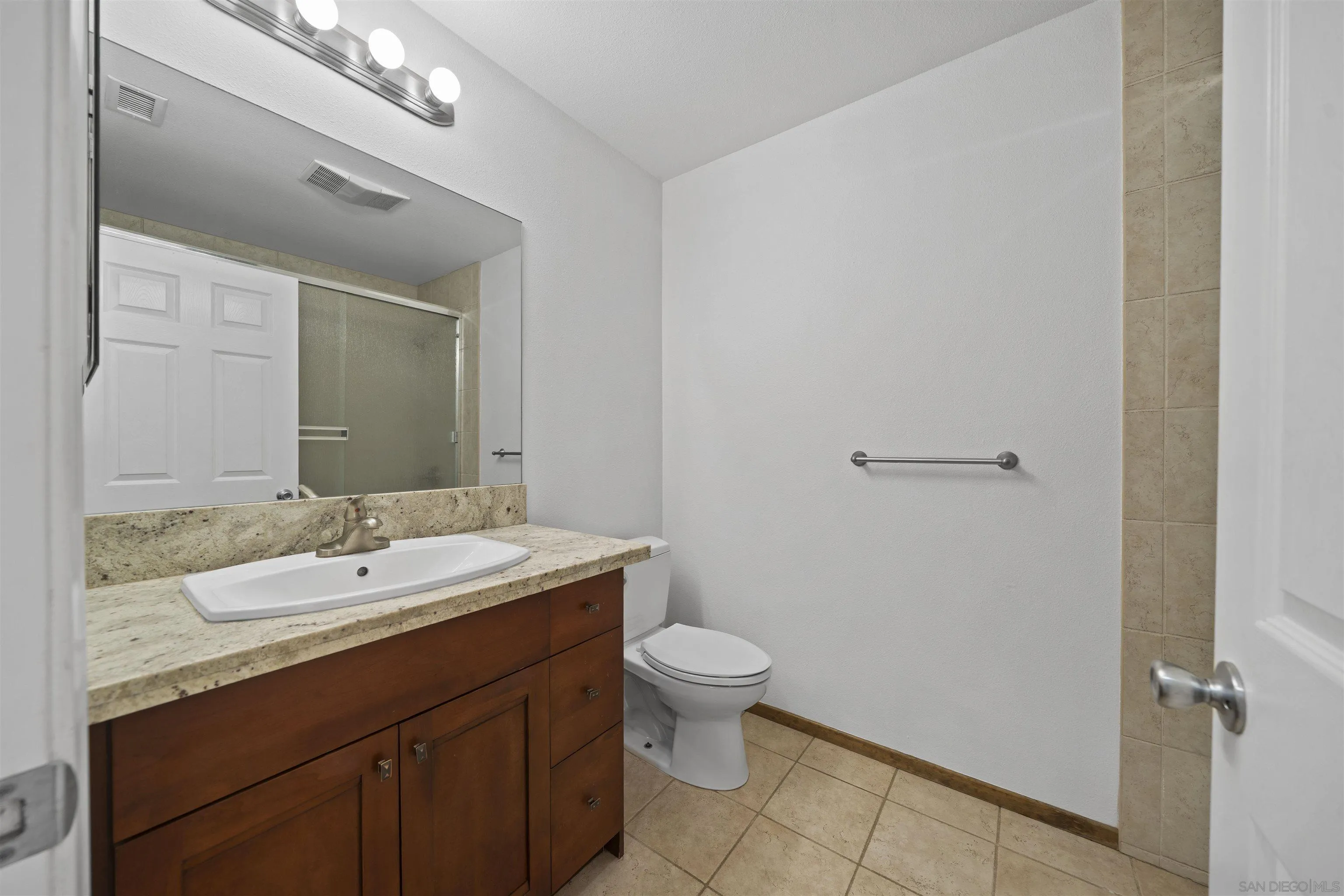 20872 Deerhorn Valley Road Jamul, CA 91935 - Photo 22 of 64 a bathroom with a granite countertop sink a toilet and a mirror