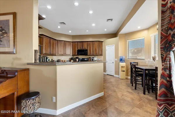 a kitchen with stainless steel appliances granite countertop a refrigerator and a stove top oven