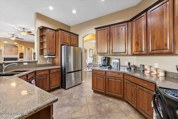 a kitchen with stainless steel appliances granite countertop a refrigerator a sink dishwasher stove with granite countertops and cabinets