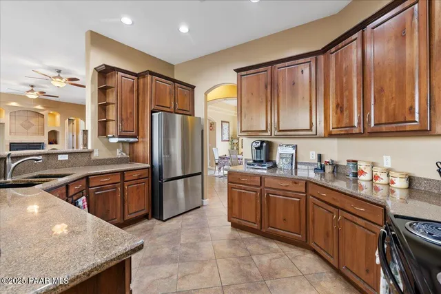 a kitchen with stainless steel appliances granite countertop a refrigerator a sink dishwasher stove with granite countertops and cabinets