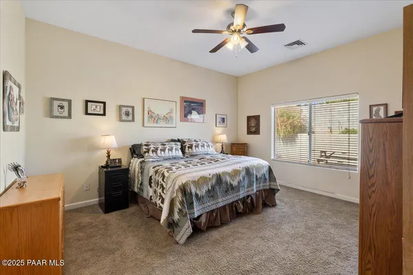 a spacious bedroom with a bed and a chandelier