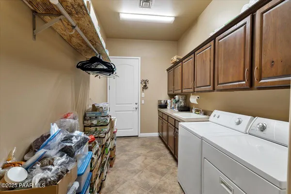 a view of a storage & utility room with sink dryer and washer