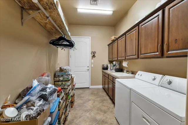 a view of a storage & utility room with sink dryer and washer