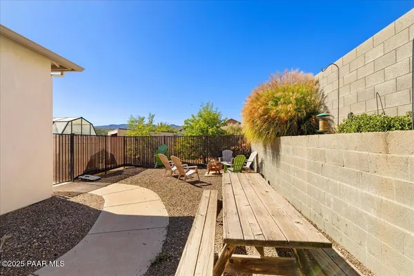 a view of a patio with dining table and chairs with wooden fence