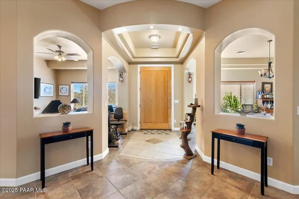 a living room with furniture a large window and potted plants