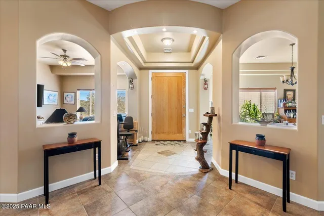 a living room with furniture a large window and potted plants