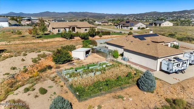 an aerial view of residential houses with outdoor space and trees