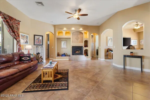 a living room with furniture a fireplace and a chandelier