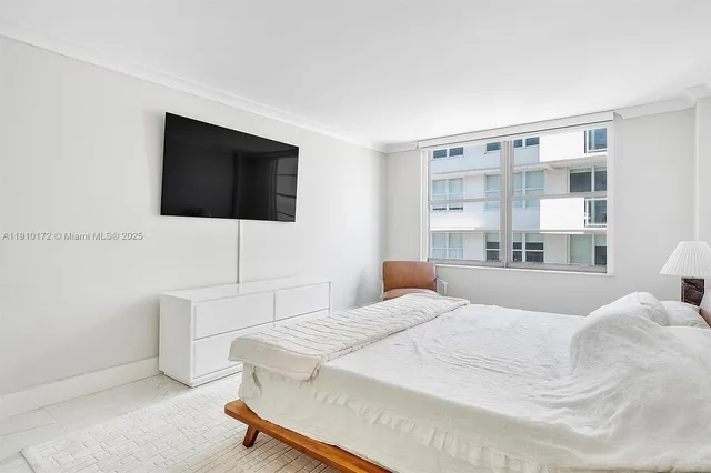 a bedroom with a large bed and a flat screen tv