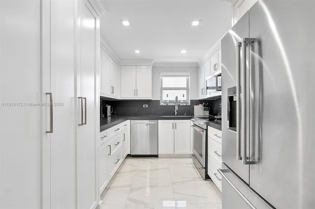 a kitchen with stainless steel appliances a refrigerator sink and microwave