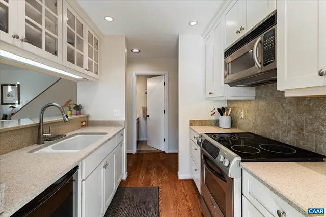 a kitchen with stainless steel appliances a sink stove and cabinets
