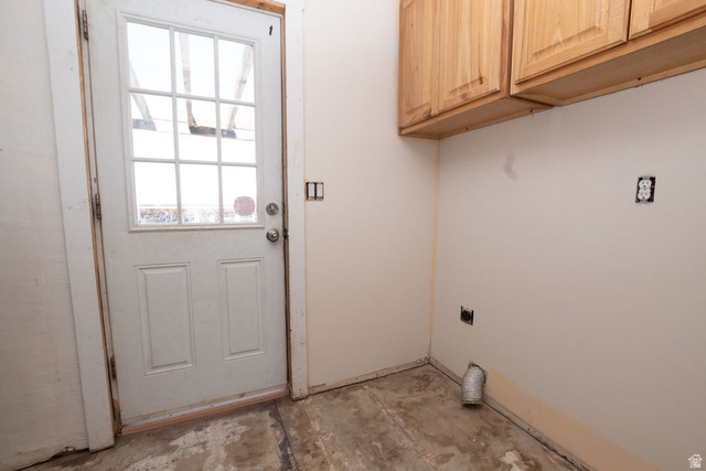 570 West Main Street Beaver, UT 84713 - Photo 12 of 43 Utility space featuring a glass-paneled exterior door, overhead wood cabinetry, and exposed electrical outlets