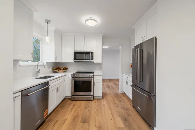 a kitchen with stainless steel appliances a refrigerator sink and microwave