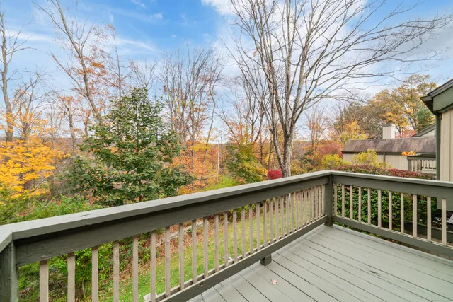 a view of balcony with wooden floor and fence