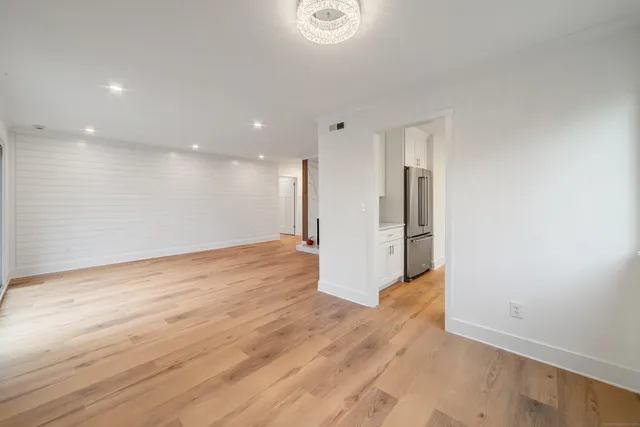 a view of a big room with wooden floor and windows