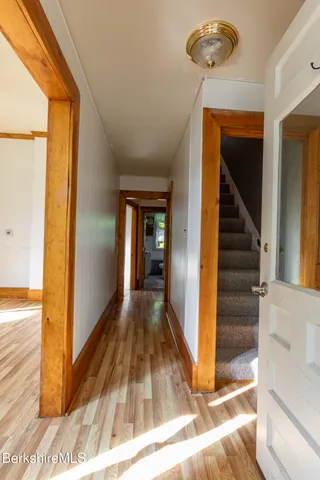 a view of a hallway with wooden floor and staircase
