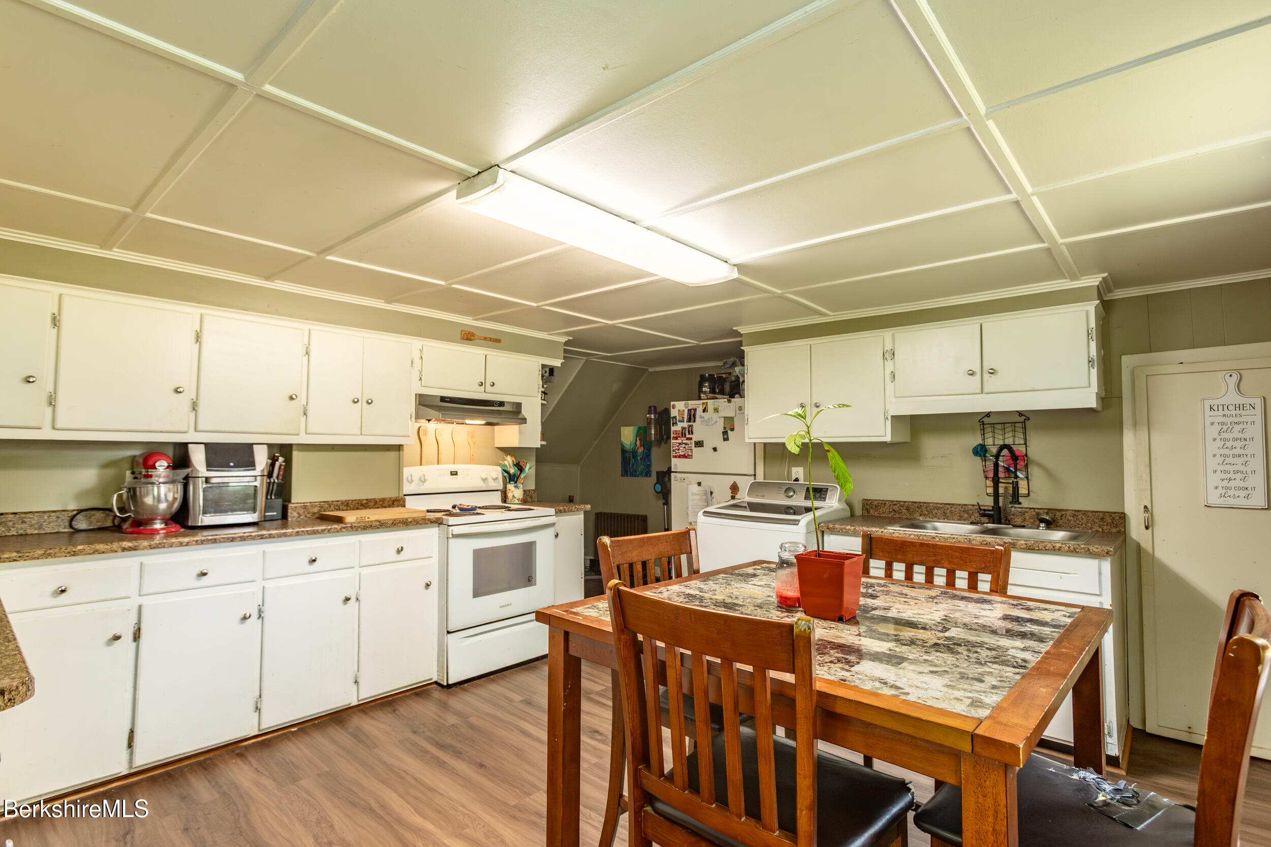89-91 Pecks Road Pittsfield, MA 01201 - Photo 20 of 28 a kitchen with kitchen island granite countertop a sink a stove a dining table and chairs
