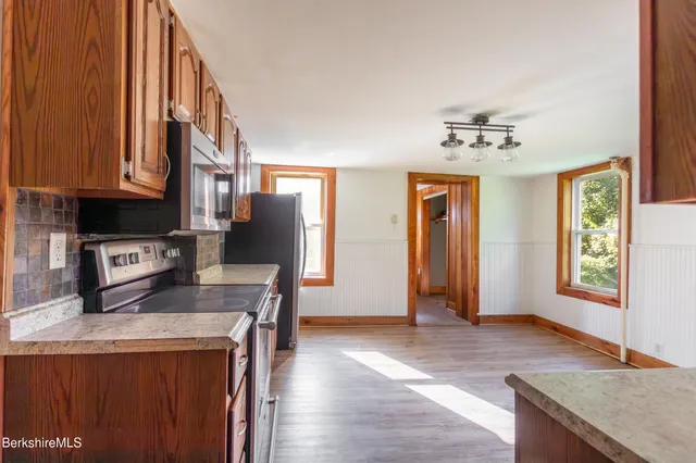 a kitchen with stainless steel appliances granite countertop a sink a stove and a refrigerator