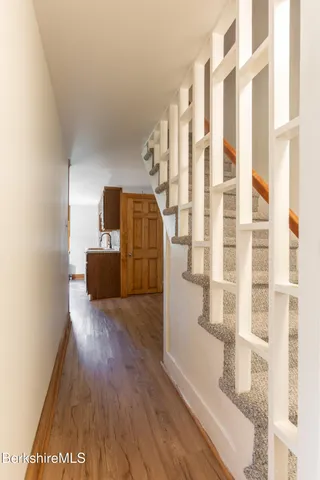 a view of front door with hallway and wooden floor