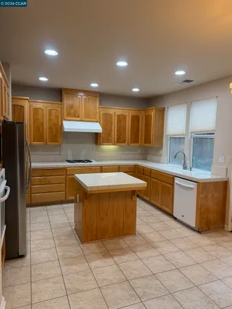 a kitchen with stainless steel appliances granite countertop a sink and a refrigerator