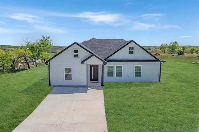 a house with green field in front of it