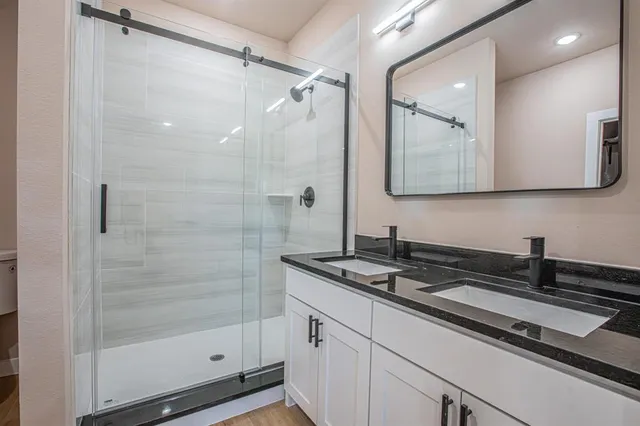 a bathroom with a sink a shower and mirror