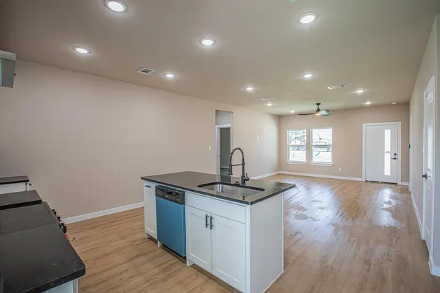 a kitchen with kitchen island a sink stove and wooden floor